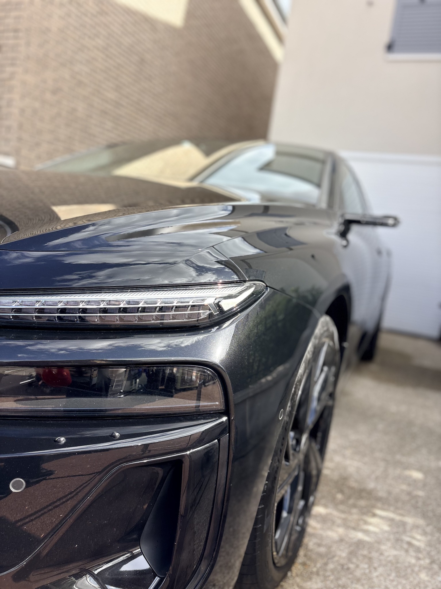 Coin avant et feu de jour d'une Audi A6 e-tron, peinture noire brillante
